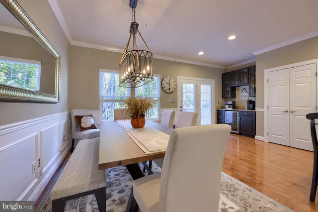 a view of a dining room with furniture a chandelier and wooden floor