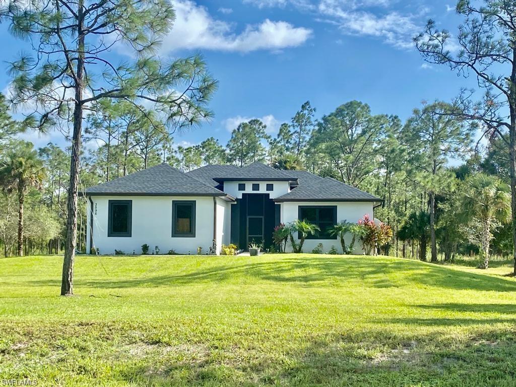 a front view of house with yard and green space