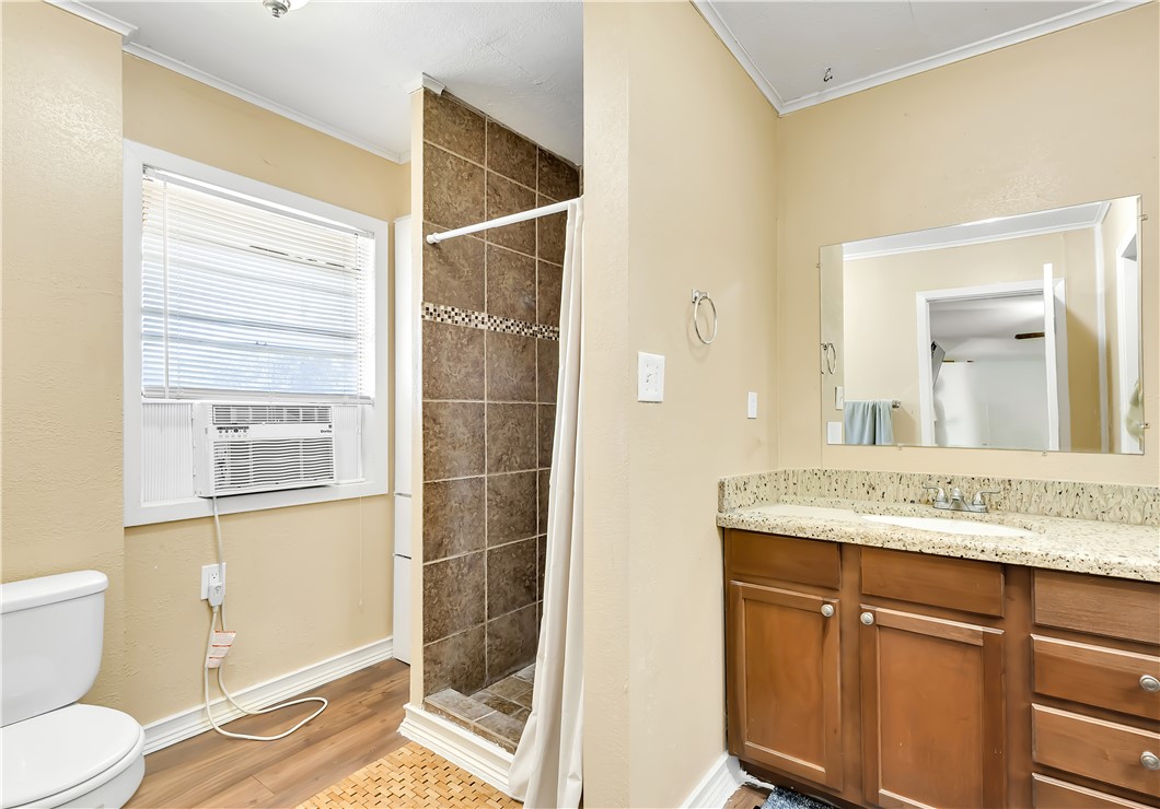 520 Helena Street Bryan, TX 77801 - Photo 14 of 25 a bathroom with a granite countertop sink a mirror and a shower