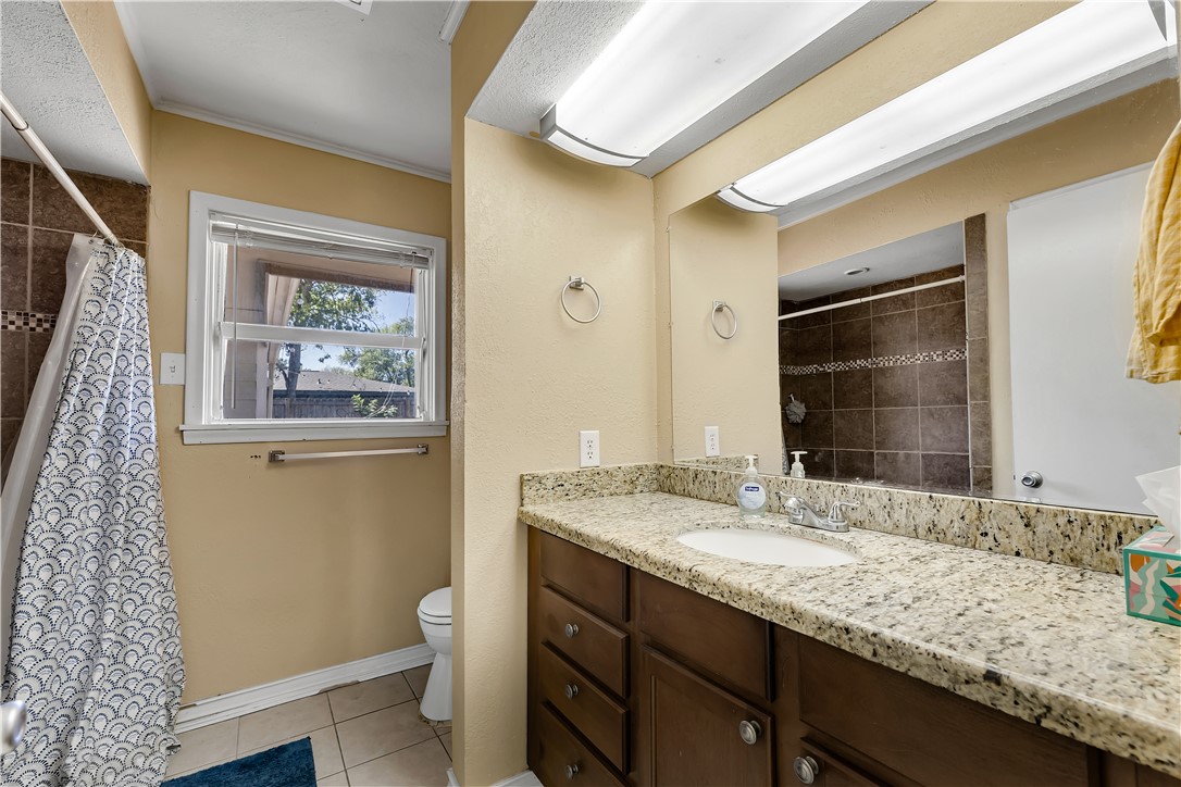 520 Helena Street Bryan, TX 77801 - Photo 7 of 25 a bathroom with a granite countertop sink and a mirror
