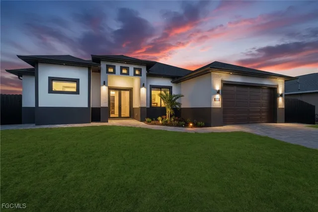 a front view of a house with a garden and yard
