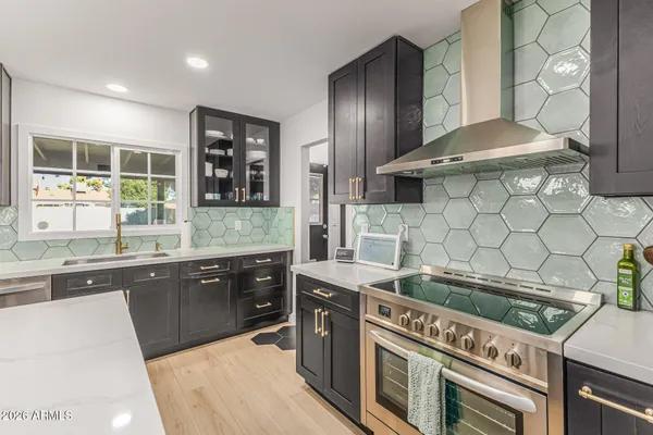 a kitchen with stainless steel appliances a sink stove and cabinets