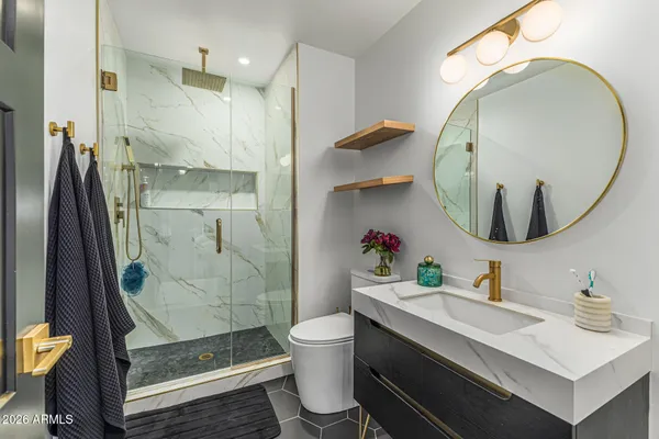 a bathroom with a sink a toilet and a mirror