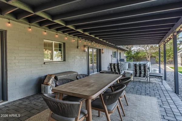 a view of a patio with a table and chairs and a barbeque