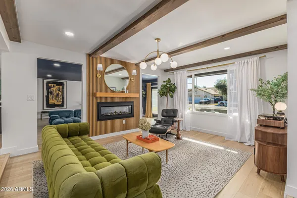 a living room with furniture a large window and a fireplace