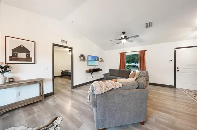 a living room with furniture ceiling fan and a rug
