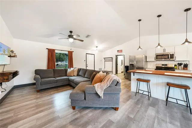 a bedroom with a bed a ceiling fan and a dresser