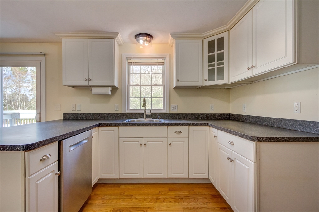17 Lynne Road Wareham, MA 02571 - Photo 7 of 42 a kitchen with granite countertop white cabinets white appliances a sink and a window