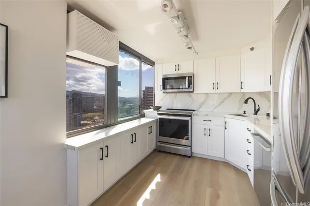 a kitchen with granite countertop white cabinets and white appliances