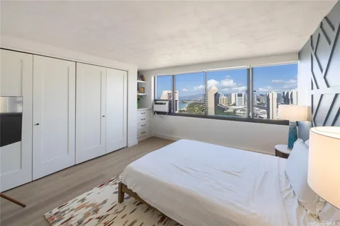 a bed room with a bed and a view of kitchen