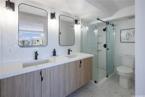 a bathroom with a double vanity sink toilet and a mirror