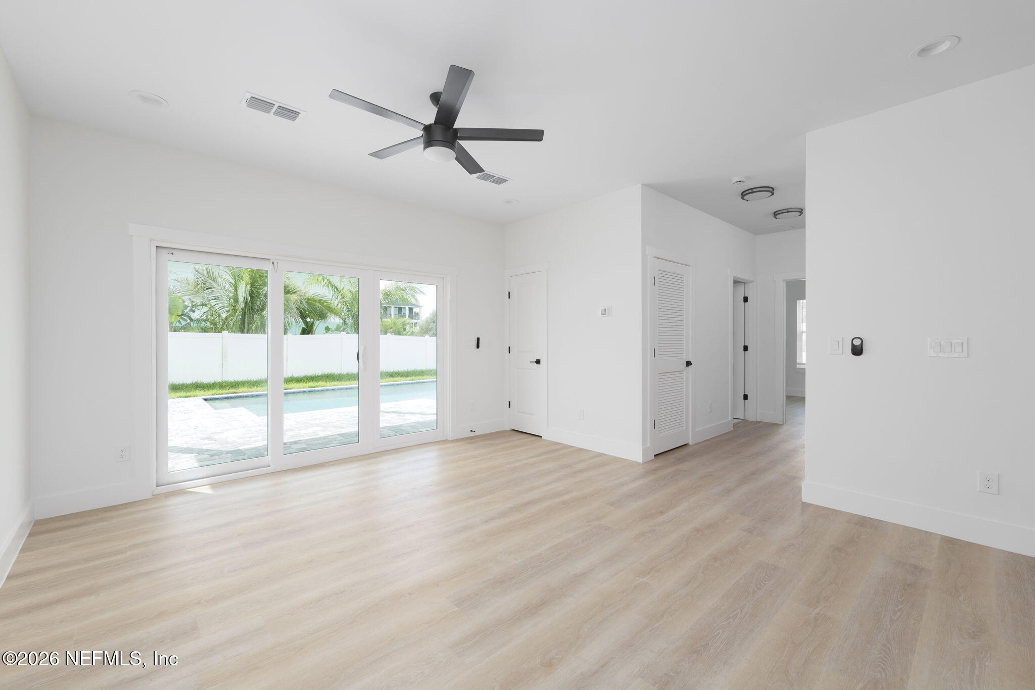 213 Twenty-First Street St. Augustine, FL 32084 - Photo 10 of 50 an empty room with wooden floor fan and windows