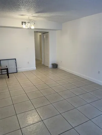 a view of a livingroom with an empty space and a window