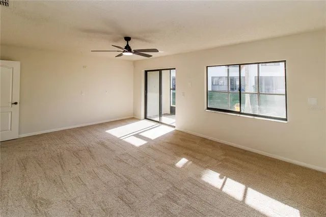 an empty room with a ceiling fan and a window