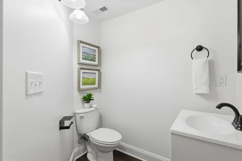 a bathroom with a sink mirror vanity and toilet