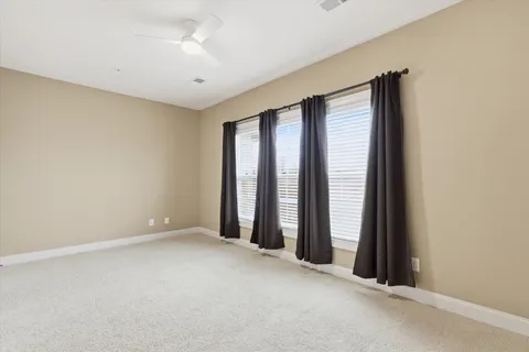 an empty room with windows and closet area