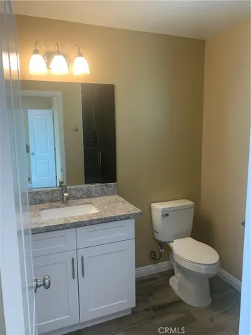 a bathroom with a granite countertop toilet and a sink