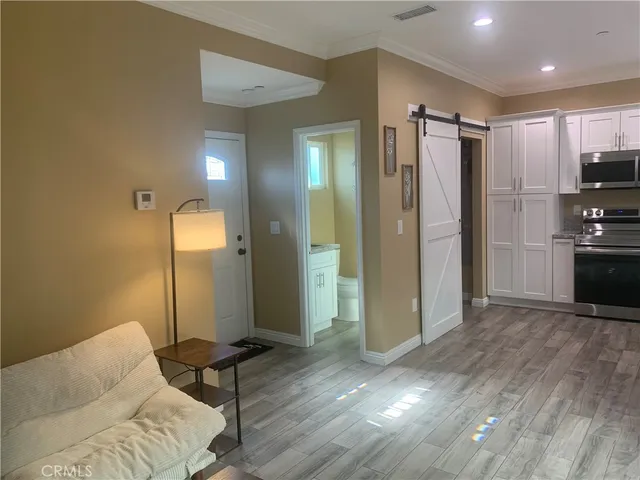 a living room with furniture and a refrigerator
