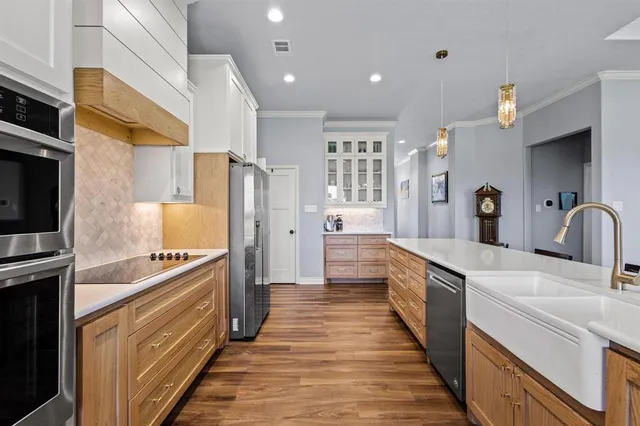 a kitchen with stainless steel appliances granite countertop a sink and a refrigerator