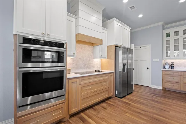 a kitchen with stainless steel appliances a stove a refrigerator and cabinets