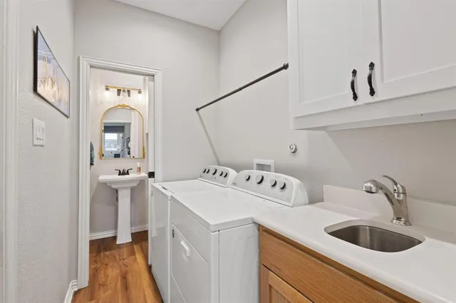 a view of a sink and dishwasher with wooden floor