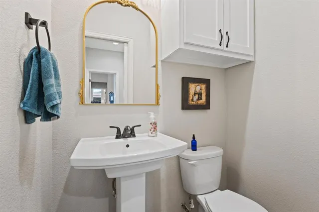 a bathroom with a toilet a sink and mirror