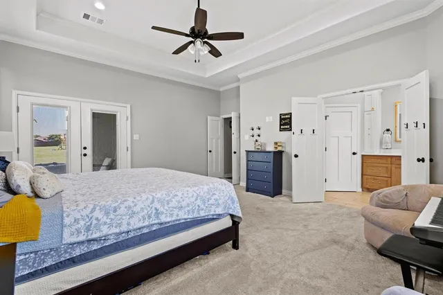 a spacious bedroom with a bed and dresser