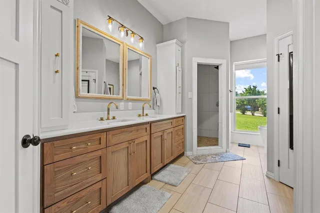 a spacious bathroom with a granite countertop sink mirror and a bathtub