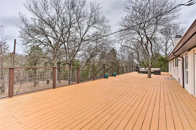 a view of wooden deck and trees with wooden fence