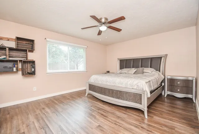 a bedroom with a large bed a flat tv screen and dresser