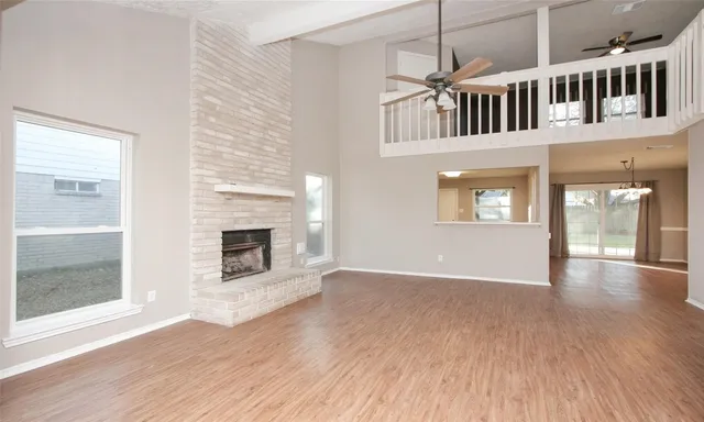 a view of an empty room with window and fire place