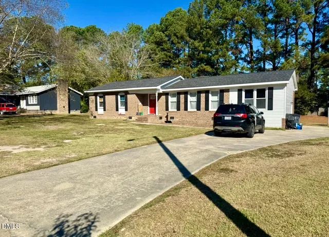 a front view of a house with a yard with seating space