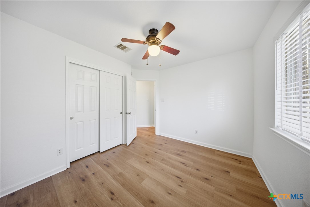 658 Devin Drive Temple, TX 76502 - Photo 24 of 30 an empty room with wooden floor ceiling fan and window