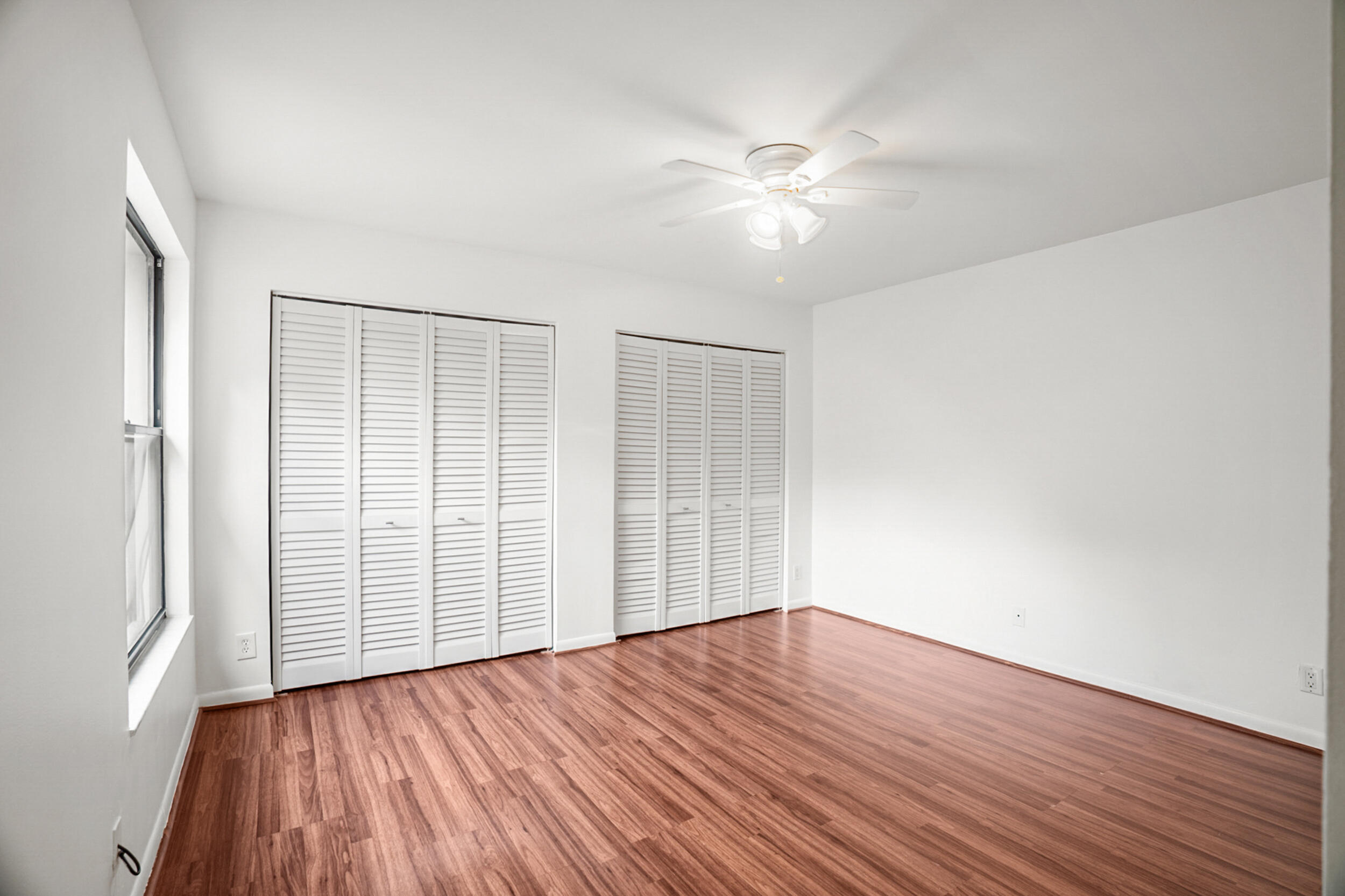 7690 Courtyard Run West Boca Raton, FL 33433 - Photo 12 of 22 an empty room with wooden floor fan and windows