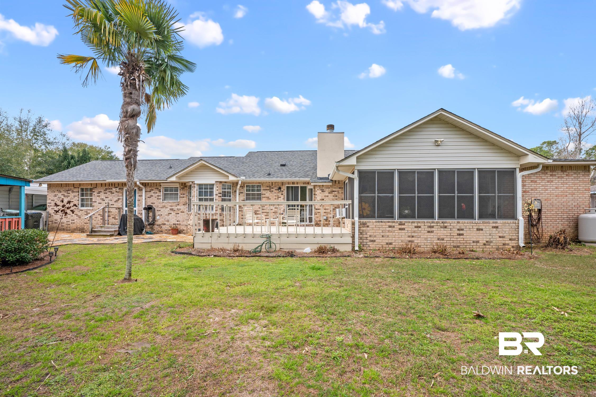 2553 Santa Rosa Drive Lillian, AL 36549 - Photo 41 of 51 Rear view of house featuring a sunroom, brick siding, a lawn, and a chimney