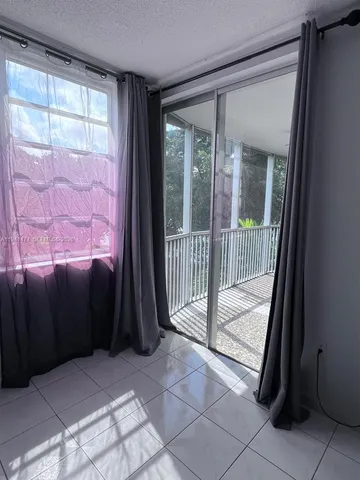 a view of a two room with wooden floor and windows