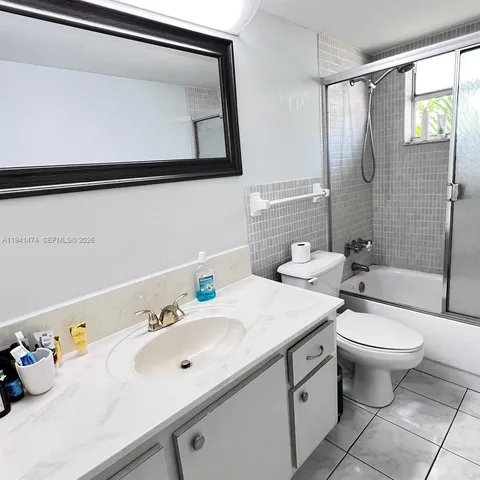 a bathroom with a sink mirror toilet and shower