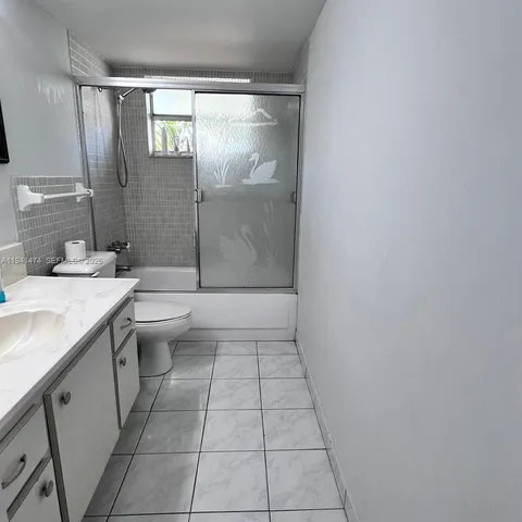 a bathroom with a granite countertop sink a toilet and a mirror