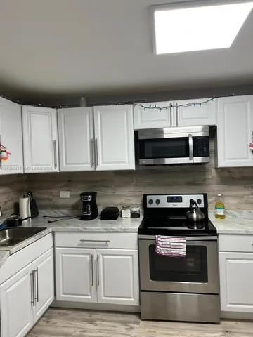 a kitchen with stainless steel appliances granite countertop a stove a microwave and cabinets