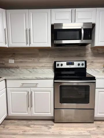 a kitchen with granite countertop a stove and a microwave