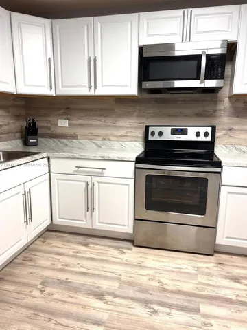 a kitchen with stainless steel appliances granite countertop a stove microwave and oven