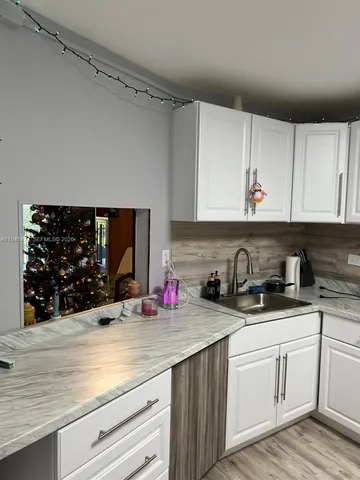 a kitchen with white cabinets a sink and dishwasher