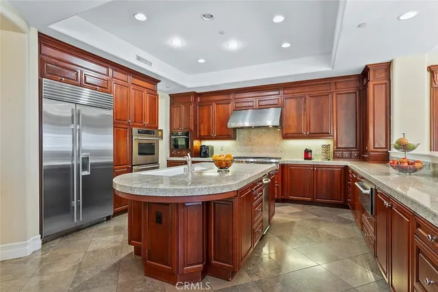 a kitchen with stainless steel appliances granite countertop a sink a stove and a refrigerator