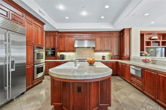 a kitchen with stainless steel appliances granite countertop a sink a refrigerator and a stove