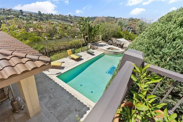 a view of a swimming pool with a patio and a yard