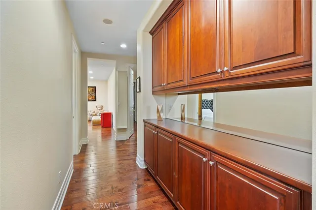 a hallway with view of kitchen with wooden floor