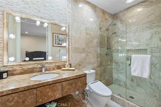 a bathroom with a granite countertop toilet sink and shower