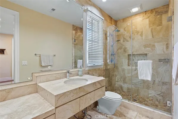 a bathroom with a sink toilet a mirror and shower