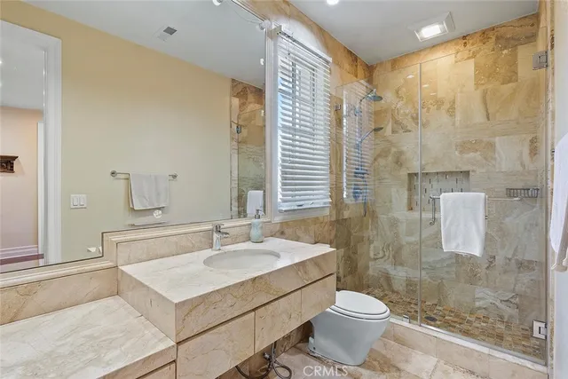 a bathroom with a sink toilet a mirror and shower