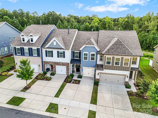 an aerial view of a house with a garden and lake view